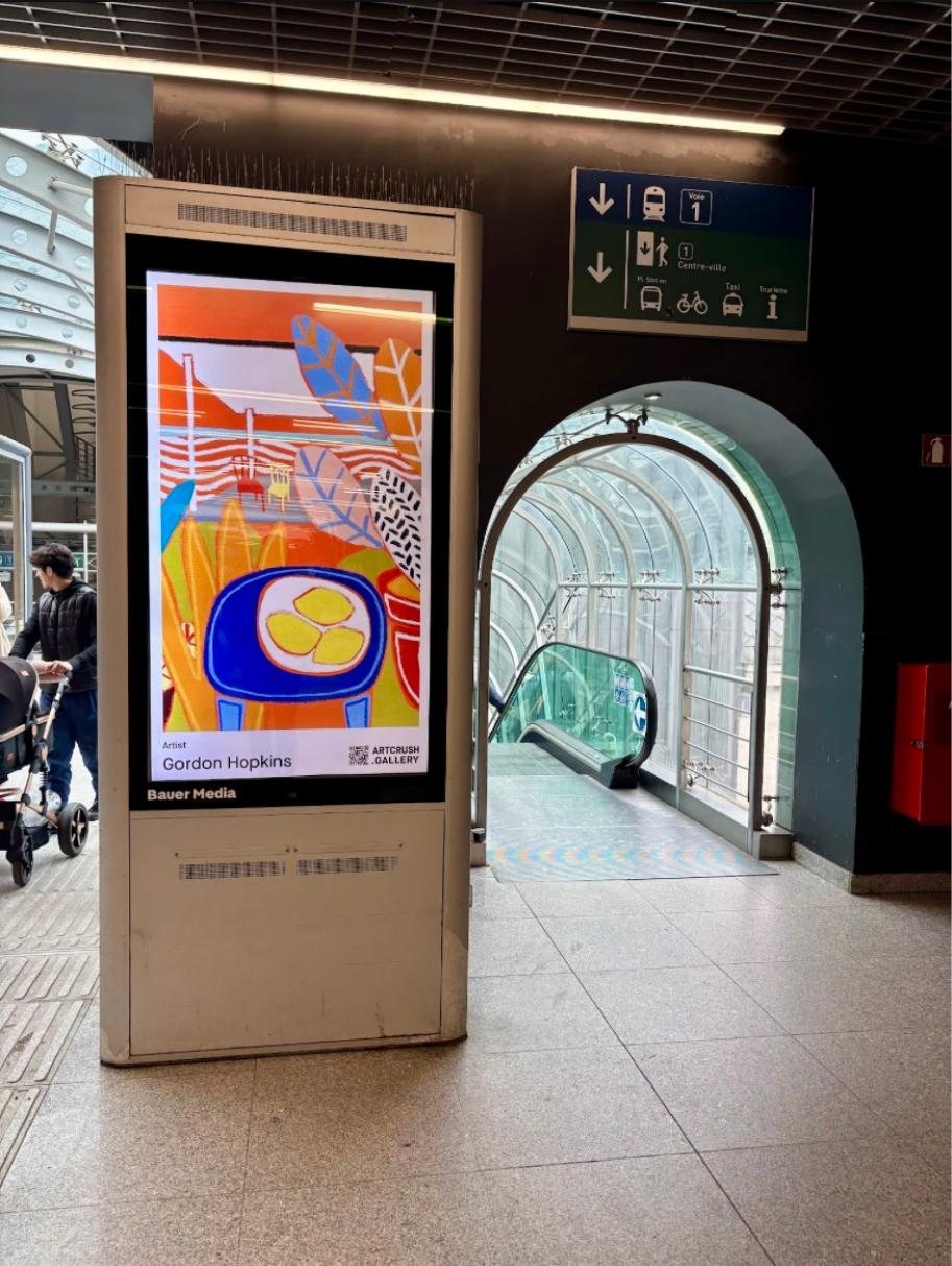 Gordon Hopkins on a digital column in a Belgian station